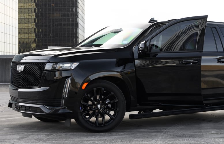 Doors open on a bulletproof armored luxury suv for rent on a Houston roofop